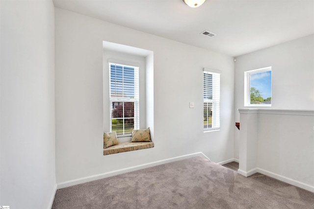 carpeted spare room with baseboards and visible vents