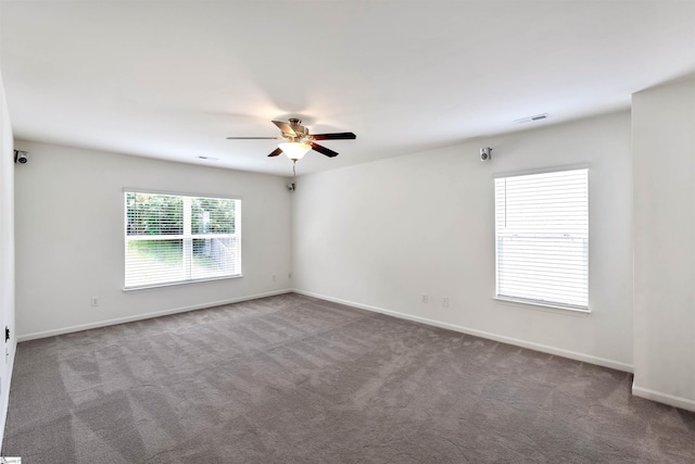 carpeted empty room featuring a ceiling fan, baseboards, and visible vents