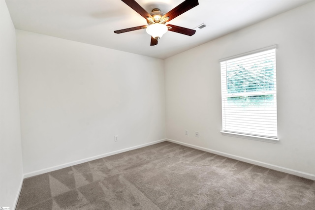 empty room featuring baseboards, ceiling fan, visible vents, and carpet floors