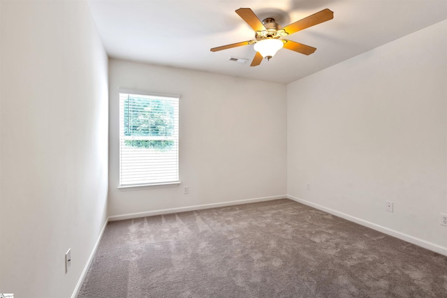 carpeted empty room with visible vents, baseboards, and ceiling fan