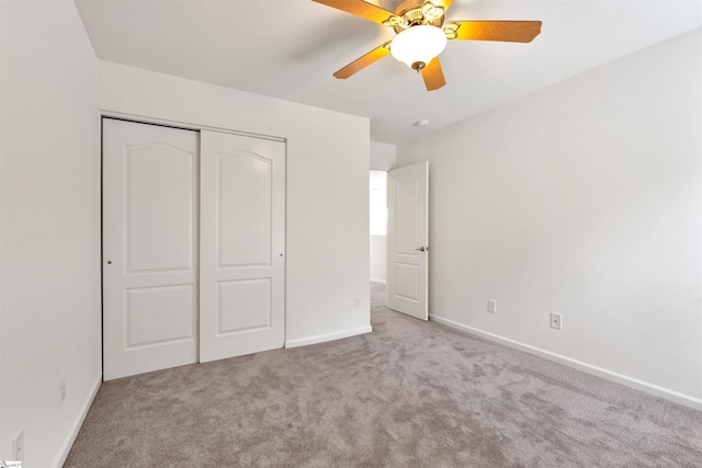 unfurnished bedroom featuring carpet flooring, a closet, baseboards, and ceiling fan