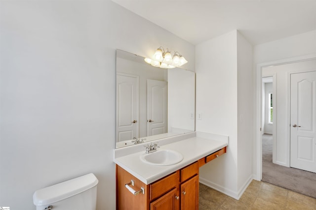 bathroom with vanity, toilet, and baseboards
