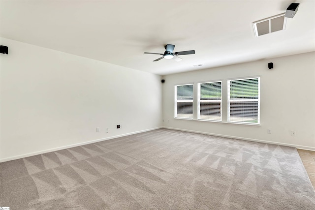 empty room featuring ceiling fan, light carpet, and baseboards