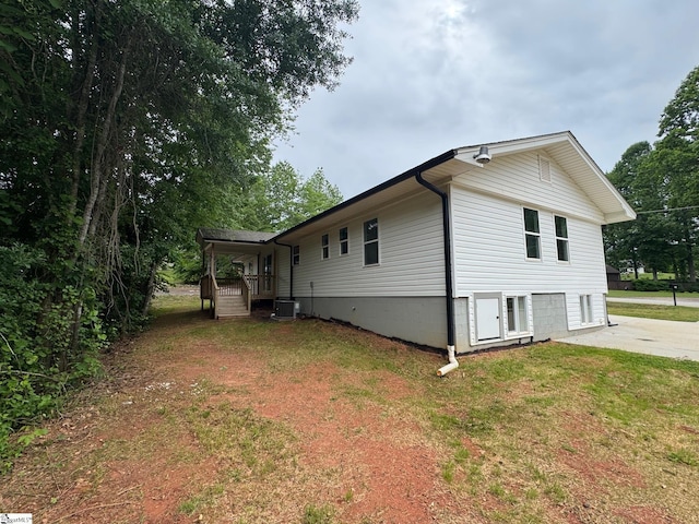 view of property exterior featuring a yard, an attached garage, central air condition unit, and driveway