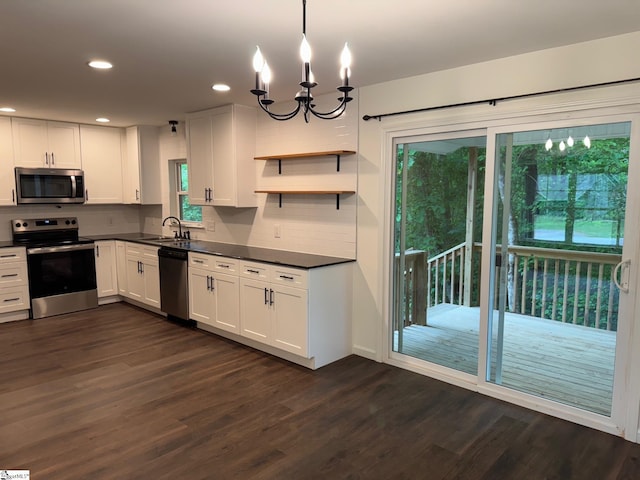 kitchen with backsplash, dark wood-style flooring, dark countertops, and appliances with stainless steel finishes