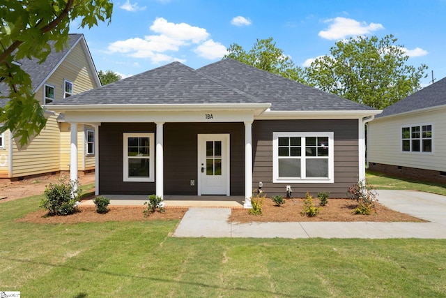view of front facade with a porch, roof with shingles, and a front lawn