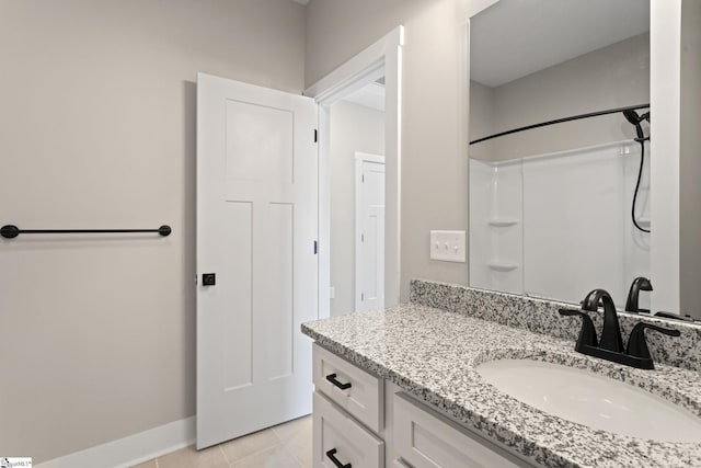full bathroom featuring vanity, baseboards, a shower, and tile patterned flooring