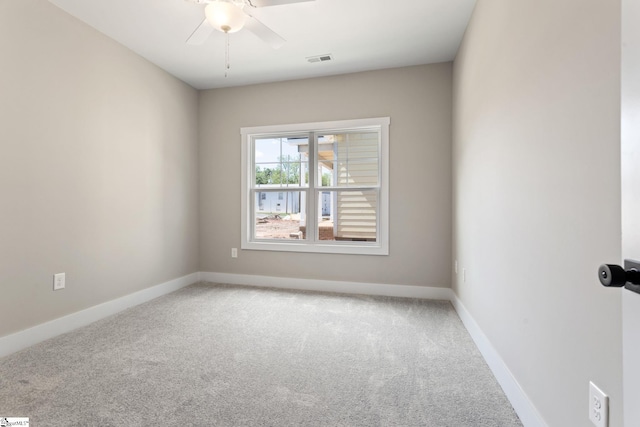 empty room featuring a ceiling fan, baseboards, visible vents, and light colored carpet