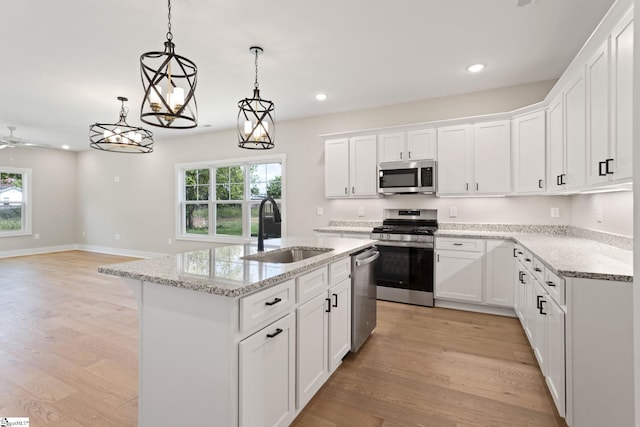 kitchen with light wood-style flooring, recessed lighting, a sink, stainless steel appliances, and an island with sink