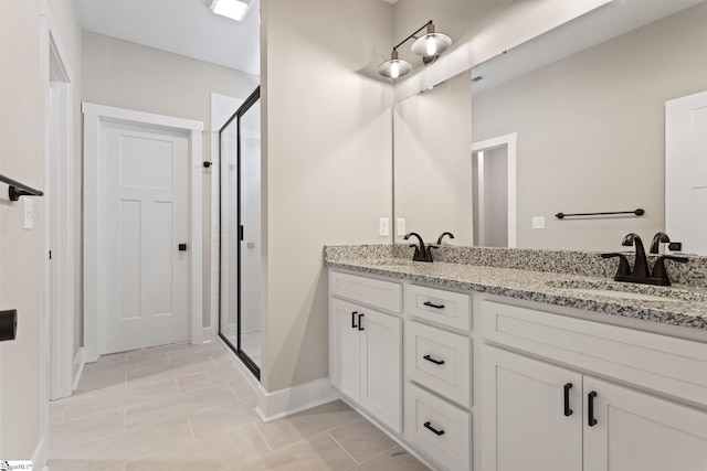 full bathroom with double vanity, a sink, tile patterned floors, baseboards, and a shower stall
