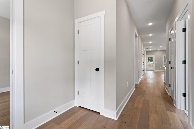 hallway with wood finished floors, baseboards, and recessed lighting
