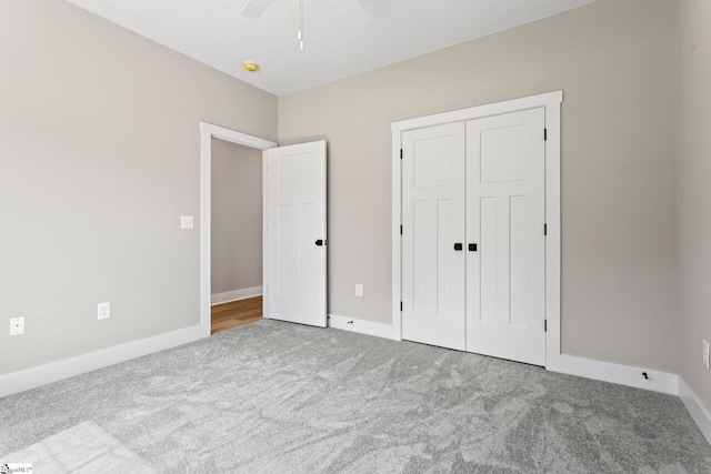unfurnished bedroom with ceiling fan, carpet flooring, a closet, and baseboards