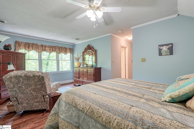 bedroom featuring a textured ceiling, baseboards, ceiling fan, crown molding, and wood finished floors
