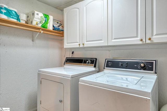 laundry room with cabinet space, independent washer and dryer, and a textured wall