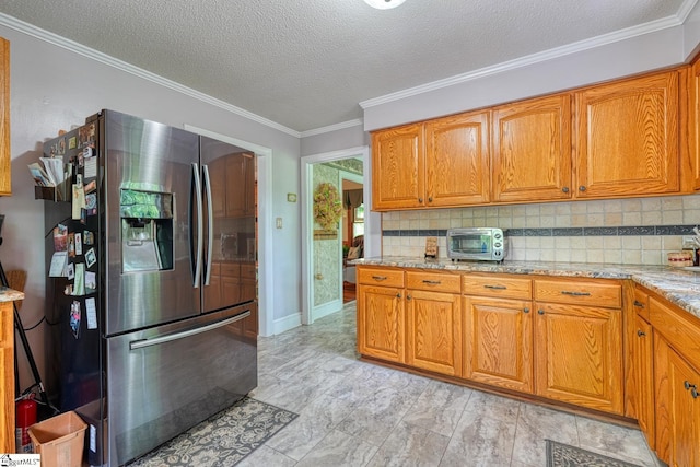 kitchen with tasteful backsplash, stainless steel refrigerator with ice dispenser, and brown cabinets