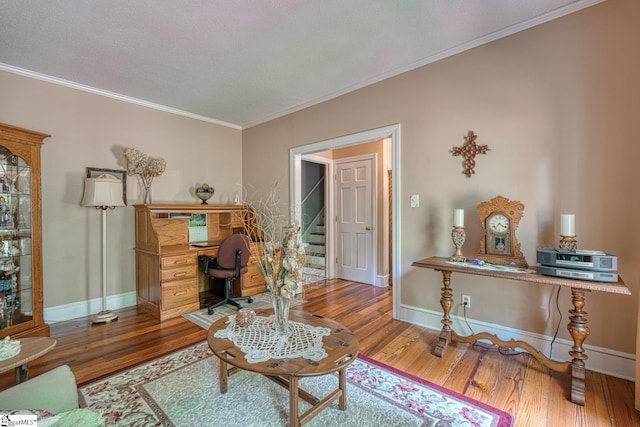 office area with crown molding, wood finished floors, and baseboards