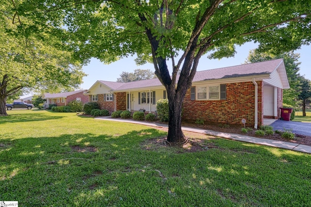 ranch-style home with brick siding and a front yard