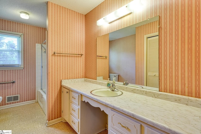 bathroom with vanity, toilet, visible vents, and wallpapered walls
