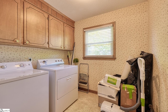 laundry area featuring a textured ceiling, cabinet space, independent washer and dryer, and wallpapered walls