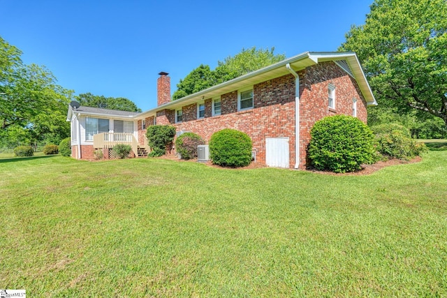 ranch-style home with a front lawn, brick siding, and a chimney