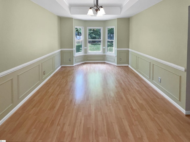 102 Thurber Way, Simpsonville, SC 29681 - unfurnished room with a wainscoted wall, a raised ceiling, a decorative wall, and light wood-type flooring