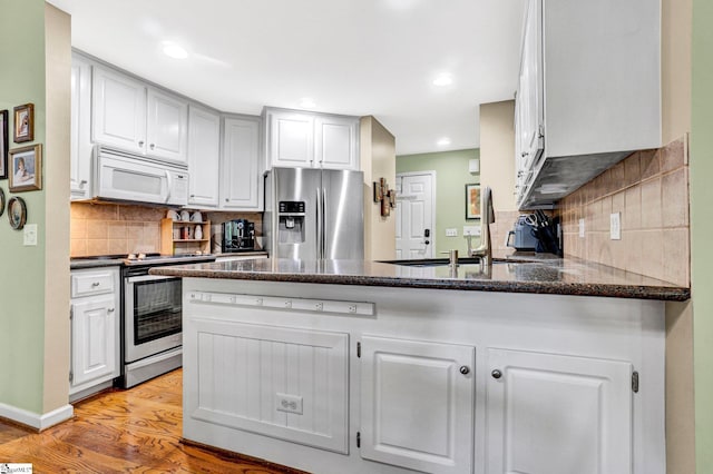 6 Shallow Creek Ct, Fountain Inn, SC 29644 - kitchen with a sink, a peninsula, stainless steel appliances, dark stone counters, and light wood finished floors