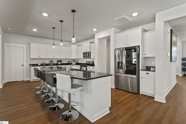 481 Fenwick Dr, Woodruff, SC 29388 - kitchen with stainless steel appliances, a breakfast bar, dark wood-style floors, baseboards, and dark countertops