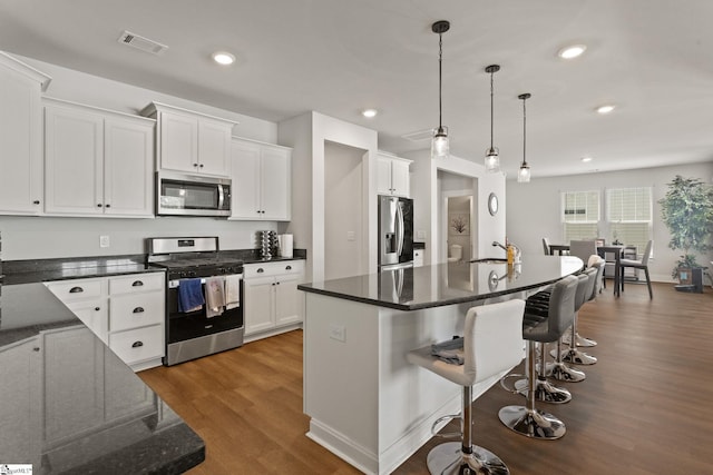 481 Fenwick Dr, Woodruff, SC 29388 - kitchen featuring a kitchen breakfast bar, white cabinets, visible vents, dark wood-type flooring, and appliances with stainless steel finishes