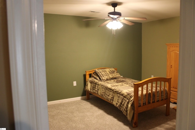 carpeted bedroom with baseboards, a ceiling fan, and visible vents