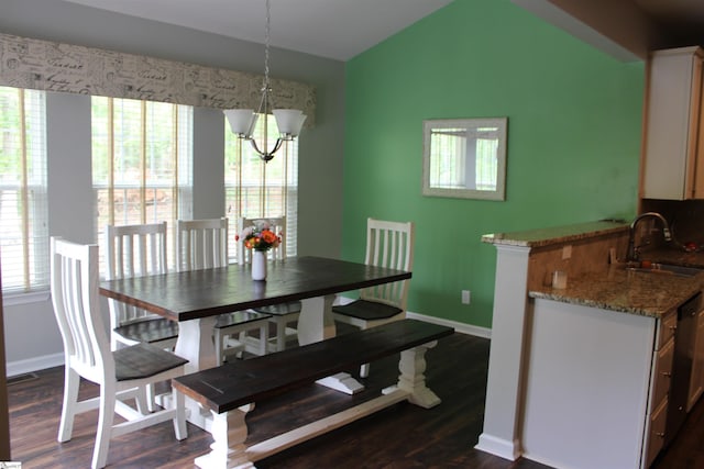 dining area featuring lofted ceiling, baseboards, a notable chandelier, and dark wood finished floors