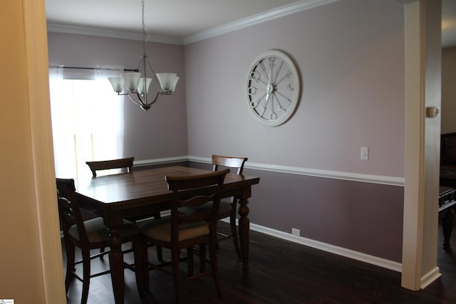dining space featuring baseboards, ornamental molding, a chandelier, and wood finished floors