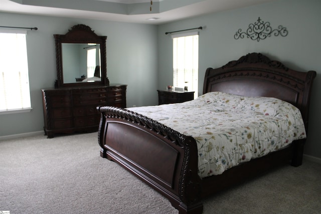 bedroom featuring light colored carpet and baseboards