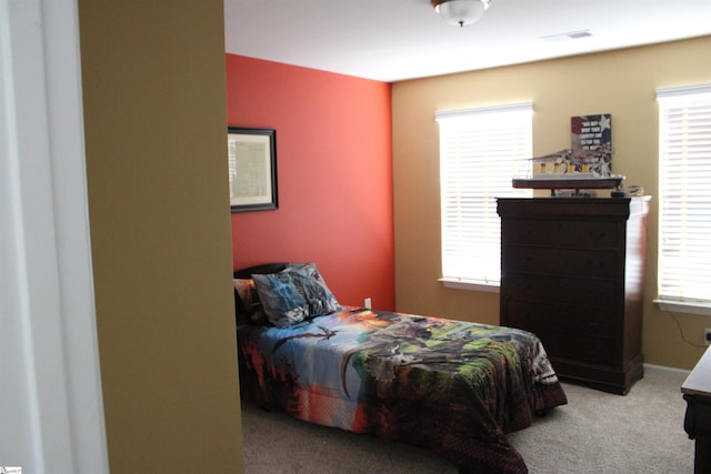 bedroom featuring multiple windows, visible vents, and carpet floors