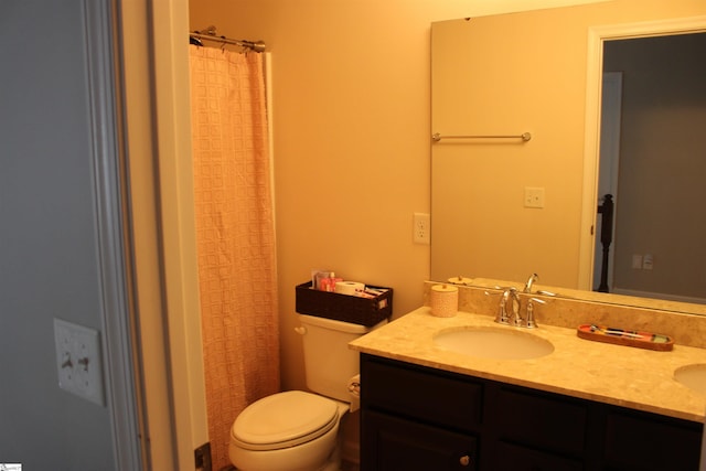 bathroom with toilet, double vanity, a sink, and a shower with shower curtain