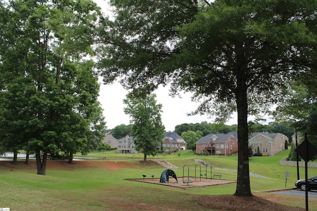 view of property's community featuring playground community, a residential view, and a lawn