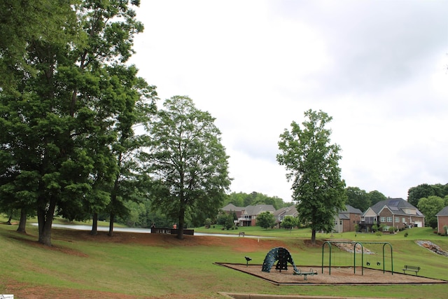 view of home's community featuring a lawn, a residential view, and playground community