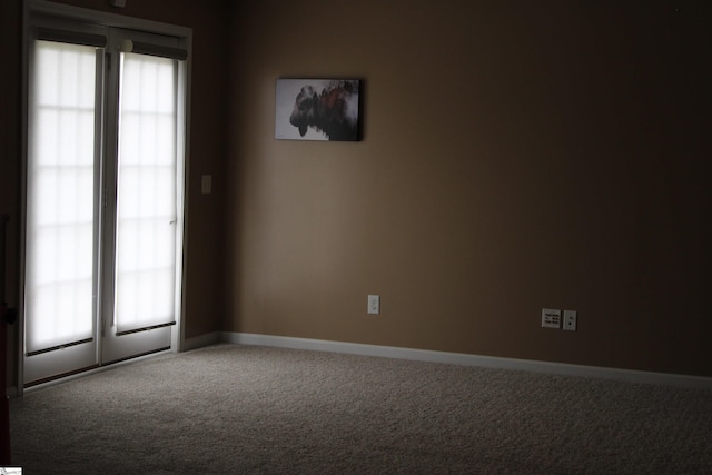 carpeted spare room with baseboards