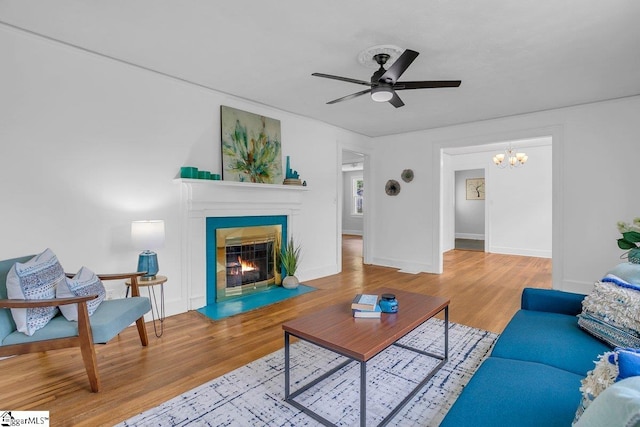 14 N Haven Dr, Greenville, SC 29617 - living room with ceiling fan with notable chandelier, a fireplace with flush hearth, baseboards, and wood finished floors