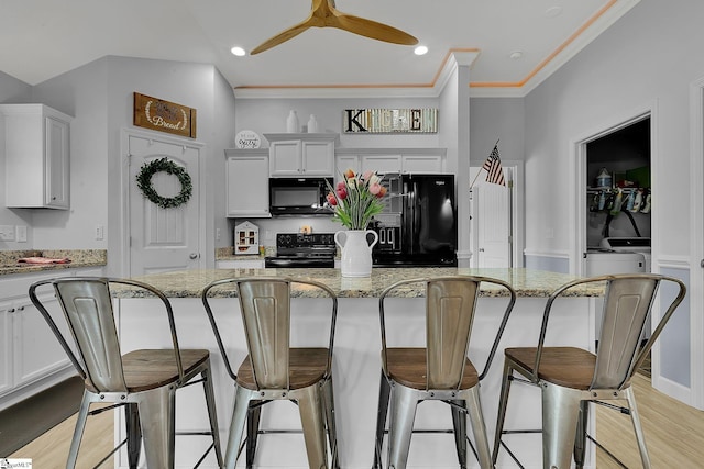 301 Highland Springs Loop, Inman, SC 29349 - kitchen featuring black appliances, a breakfast bar, light stone countertops, white cabinets, and recessed lighting