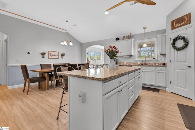 301 Highland Springs Loop, Inman, SC 29349 - kitchen featuring arched walkways, a breakfast bar, ceiling fan, light wood-style flooring, and vaulted ceiling