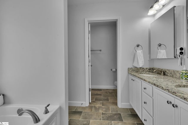 301 Highland Springs Loop, Inman, SC 29349 - full bath with stone finish flooring, toilet, baseboards, double vanity, and a garden tub