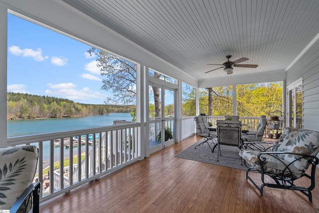 sunroom with a water view, ceiling fan, outdoor dining area, hardwood / wood-style flooring, and wood ceiling
