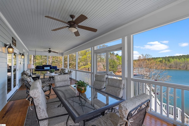 sunroom / solarium with a ceiling fan, a water view, outdoor dining space, and an outdoor living space
