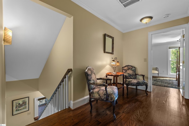 sitting room with an upstairs landing, dark wood-style flooring, baseboards, and crown molding
