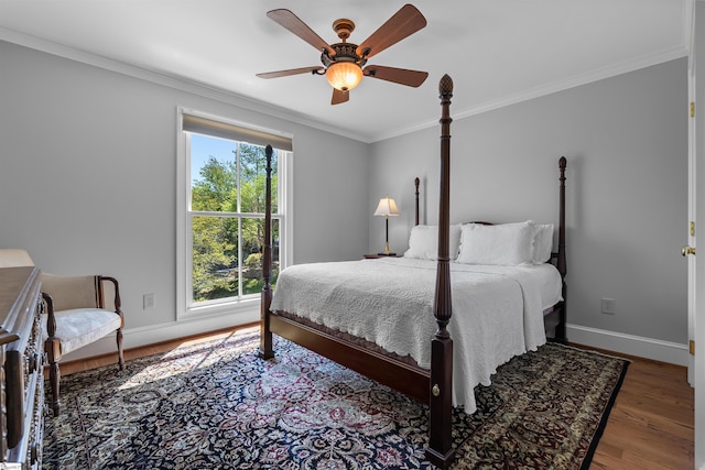 bedroom with ornamental molding, baseboards, wood finished floors, and ceiling fan