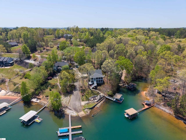 aerial view of property's location with a nearby body of water and a heavily wooded area