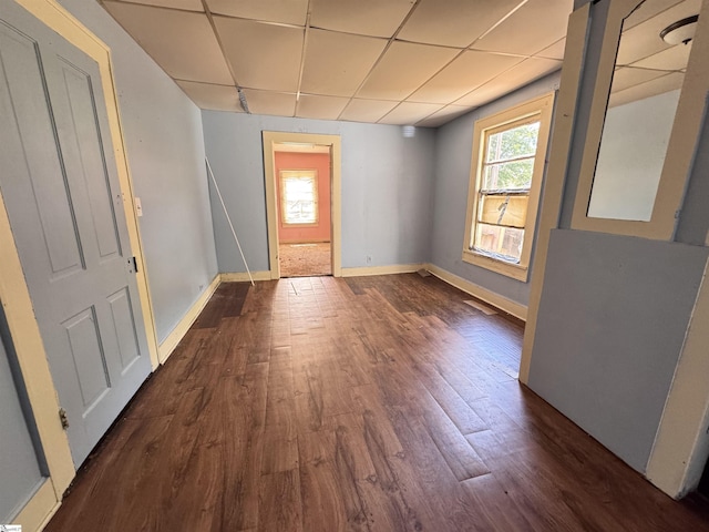 entrance foyer featuring a paneled ceiling, dark wood-type flooring, and baseboards