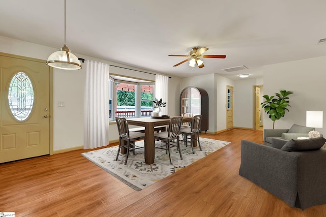 dining space featuring light wood finished floors, ceiling fan, and baseboards