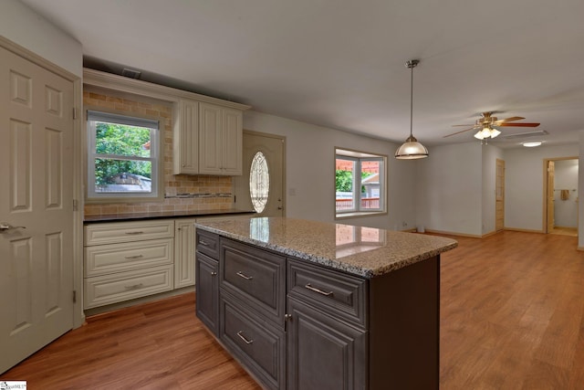 kitchen featuring healthy amount of natural light, light wood finished floors, and cream cabinets