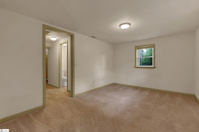 empty room with light colored carpet and baseboards